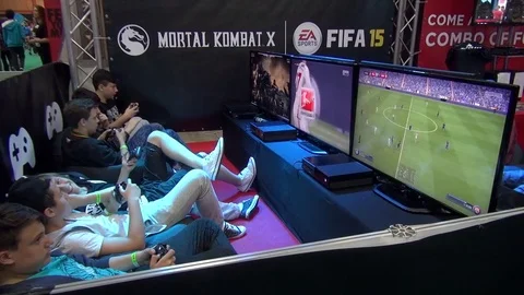 Teens playing soccer and combat video games at Comic-Con Stock Footage 71965321