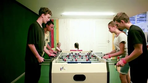 Teens playing table soccer, group of children hanging out together with table Stock Footage 74296165