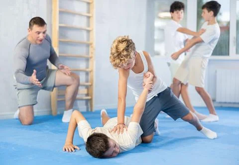 Teens practicing armlock in training bout during self defence course Stock Photos