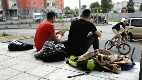 Teens resting and smoke on steps at the entrance Stock Footage 134431252