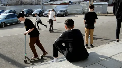 Teens ride on scooters Stock Footage 131286812