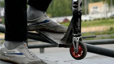 Teens on scooters performs a trick in the skatepark Stock Footage 132928540