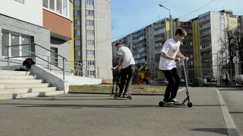 Teens on scooters performs a tricks Stock Footage 131347339