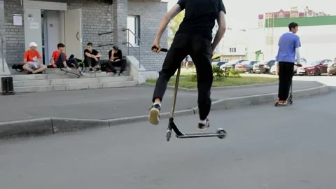 Teens on scooters performs a tricks Stock Footage 133386859