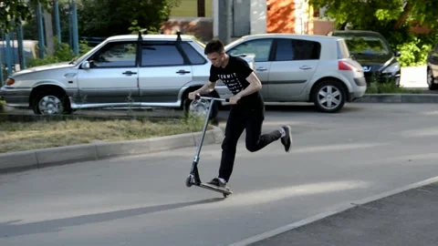 Teens on scooters performs a tricks Stock Footage 133387228