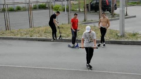 Teens on scooters performs a tricks Stock Footage 134472787