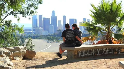 TEENS SIT IN FRONT OF DOWNTOWN Stock Footage 926218