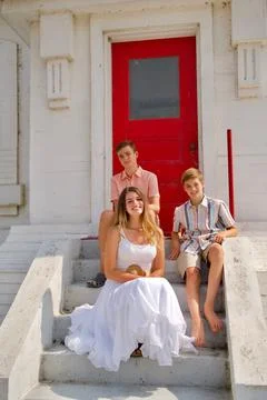 Teens sitting on steps of lighthouse Stock Photos