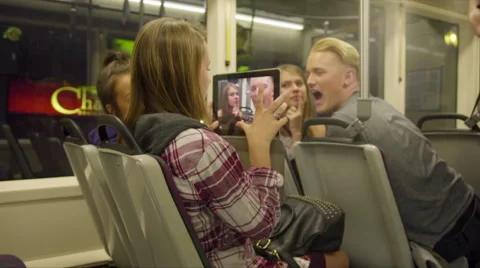 Teens taking pictures with iPad on Max train Stock Footage