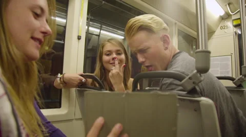 Teens travel on train while playing with their iPad Stock Footage 54262540