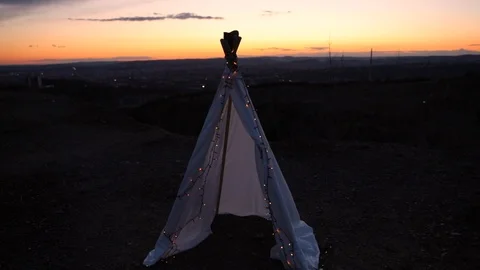 Teepee on top of hill with small chain light capture in parallax during sunset Stock-Footage 107513762