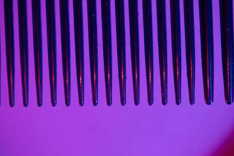 The teeth of a comb in colored light Stock Photos