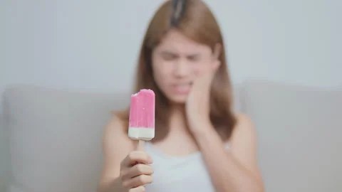 Teeth Sensitive to Cold concept. woman hold Ice cream and having toothache .. Stock Footage 273432182