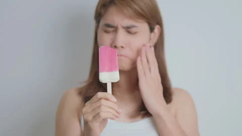 Teeth Sensitive to Cold concept. woman hold Ice cream and having toothache .. 스톡 동영상 285379210