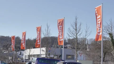 TEGUT trademark flags develop in the wind on a sunny, warm day against a blue Stock Footage 303633668
