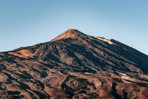Teide mountain with a dark brown peak and a blue sky in the background Stock Photos