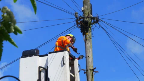 Telecom engineer working at height on wood telegraph pole with overhead cables. Vídeos de archivo 240702733