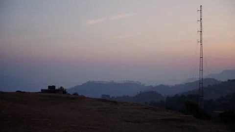 Telecom tower beside stone structure over misty hills at twilight Nepal Stock Footage 342135623