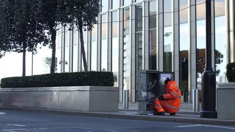 A telecom workers checks cables on a busy London street 스톡 동영상 82706970