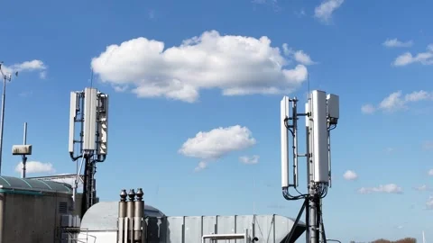 Telecommunication cell tower antennas on rooftop with moving clouds Stock Footage 333823255