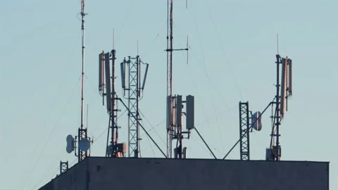 Telecommunication cell tower transmitter antennas mounted on rooftop agains.. Stock Footage 339387676