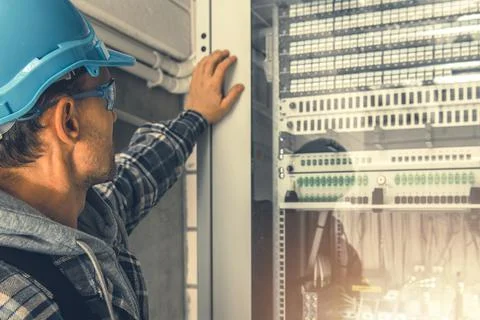 Telecommunication Technician Looking Inside Servers Rack Foto stock
