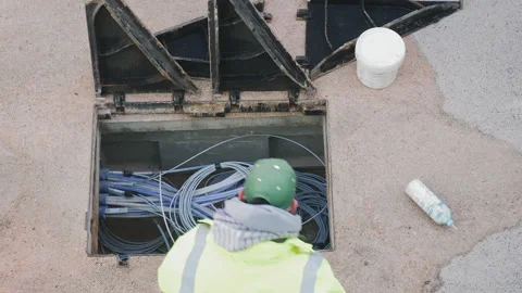 Telecommunication technician proceeds with the cabling of fibre optic cables. Video stock 254595976