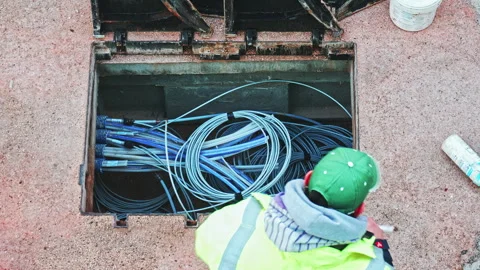 Telecommunication technician proceeds with the cabling of fibre optic cables. Video stock 281642302