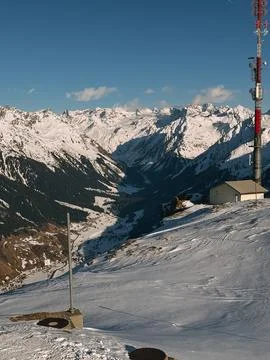 Telecommunication tower overlooking snowy mountain valley in winter Stock Photos