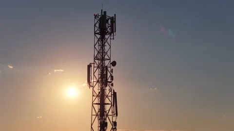 Telecommunication tower providing connectivity, silhouetted against a beautiful Stock Footage 345502497