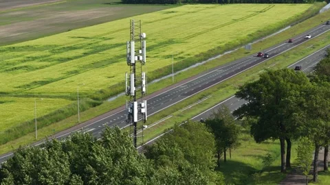 Telecommunication tower providing network coverage near highway traffic Video stock 335998049