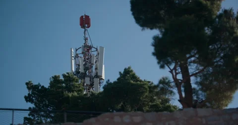 Telecommunication tower rising above pine trees in Sibenik Croatia Stock Footage 336255440