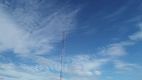 Telecommunication tower standing against blue sky with cirrus clouds Stock Footage 343501149