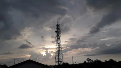 Telecommunication tower with stormy clouds background Stock Photos