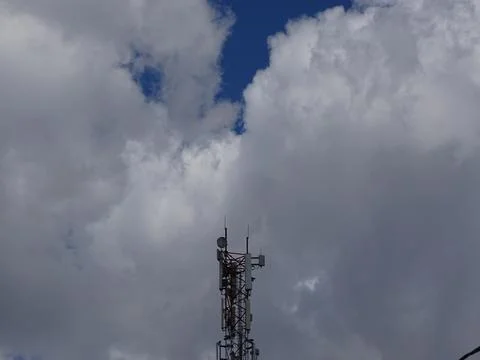 Telecommunication tower under cloudy sky Stockfoto's