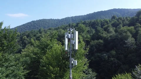 Telecommunications cell tower surrounded by mountains and forestry 動画素材 312985242