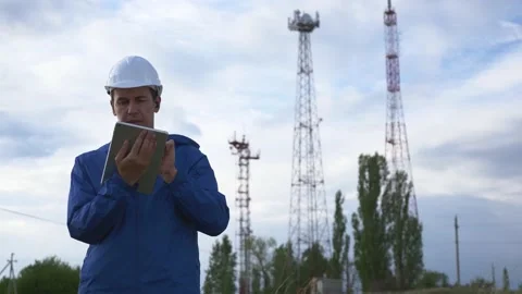 A telecommunications engineer working on a digital tablet records data for Stock Footage 136285065