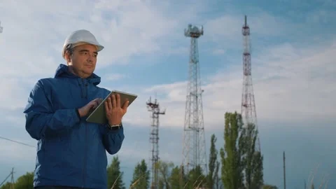 A telecommunications engineer working on a digital tablet records data for Stock Footage 136285112