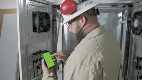 A telecommunications engineer working on a smart phone with green screen Stock Footage 156065789