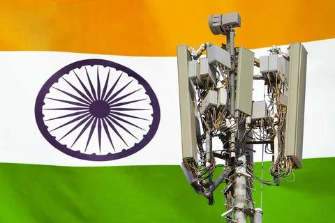 Telecommunications tower with a 5G cellular network antenna agains flag of In Foto stock