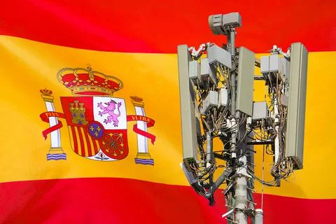 Telecommunications tower with a 5G cellular network antenna agains flag of Sp Foto stock