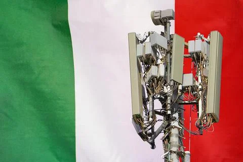 Telecommunications tower with a 5G cellular network antenna agains flag of It Stock Photos
