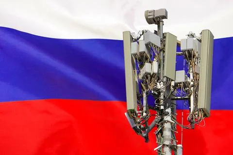 Telecommunications tower with a 5G cellular network antenna agains flag of Ru Stock Photos