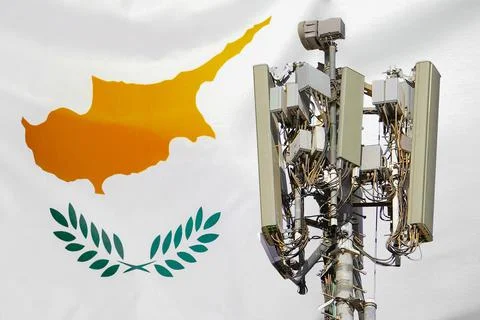 Telecommunications tower with a 5G cellular network antenna agains flag of Cy Stock Photos