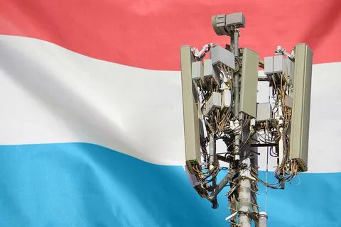 Telecommunications tower with a 5G cellular network antenna agains flag of Lu Stock Photos