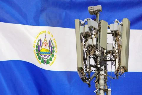 Telecommunications tower with a 5G cellular network antenna agains flag of El Stock Photos
