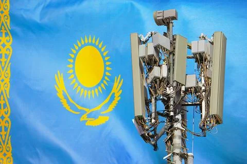 Telecommunications tower with a 5G cellular network antenna agains flag of Ka Foto stock