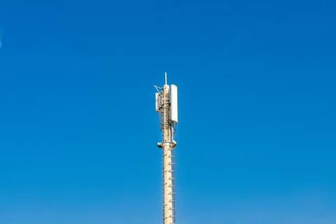 Telecommunications tower top section against blue sky Stock Photos
