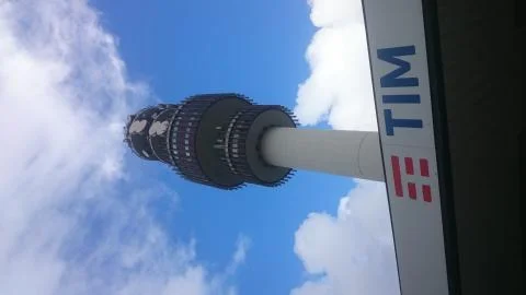 Telecomunication Tower  with TIM logo and clouds Stock Photos