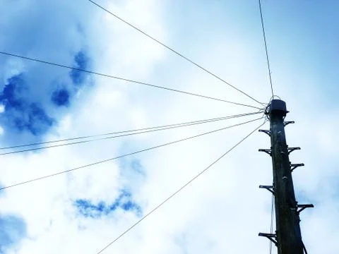 Telegraph pole on background on fluffy clouds Stock Photos